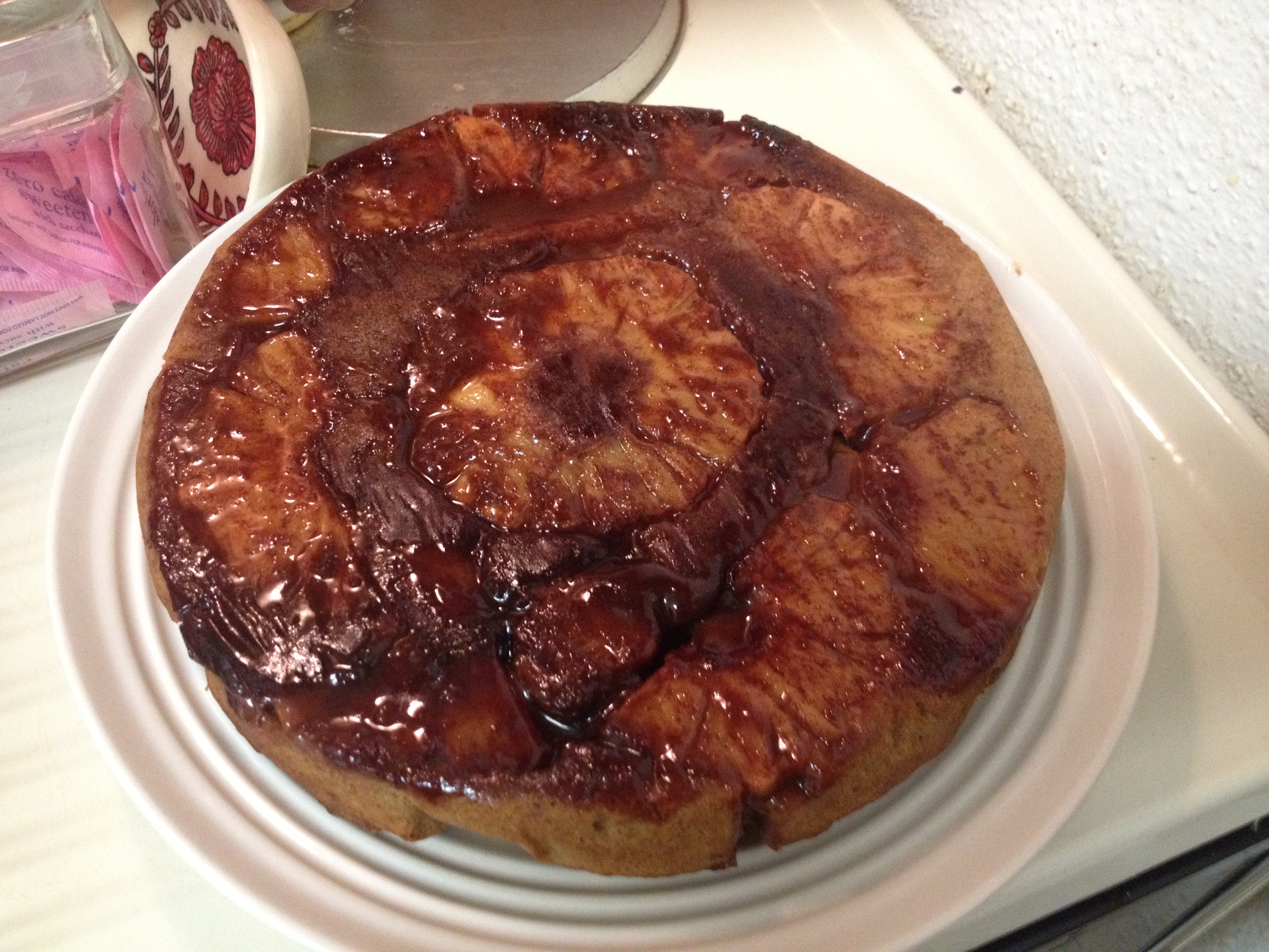 Pineapple upside down cake on a plate with pineapple on top