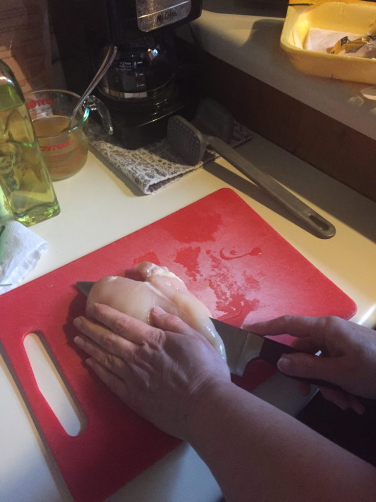 Slicing chicken breasts in half