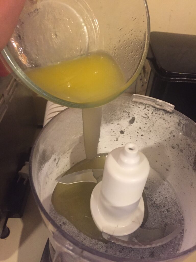 Pouring melted butter into food processor