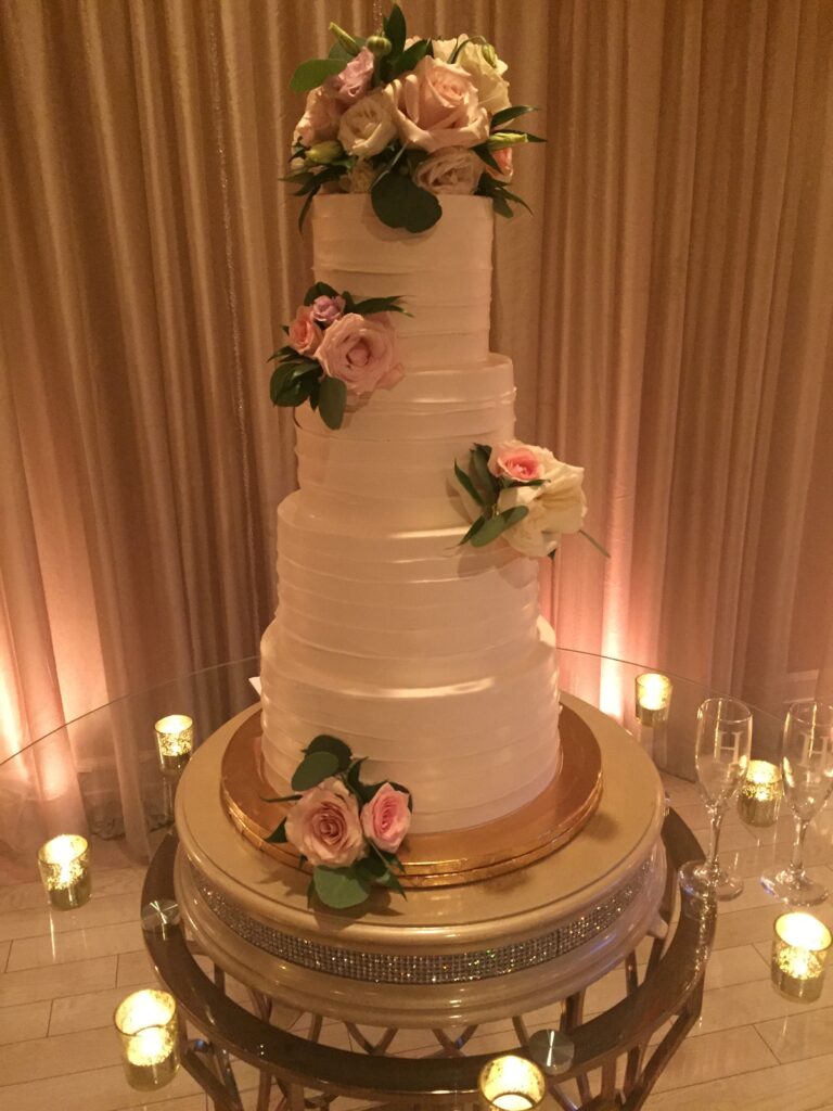 Five layer white wedding cake with flowers