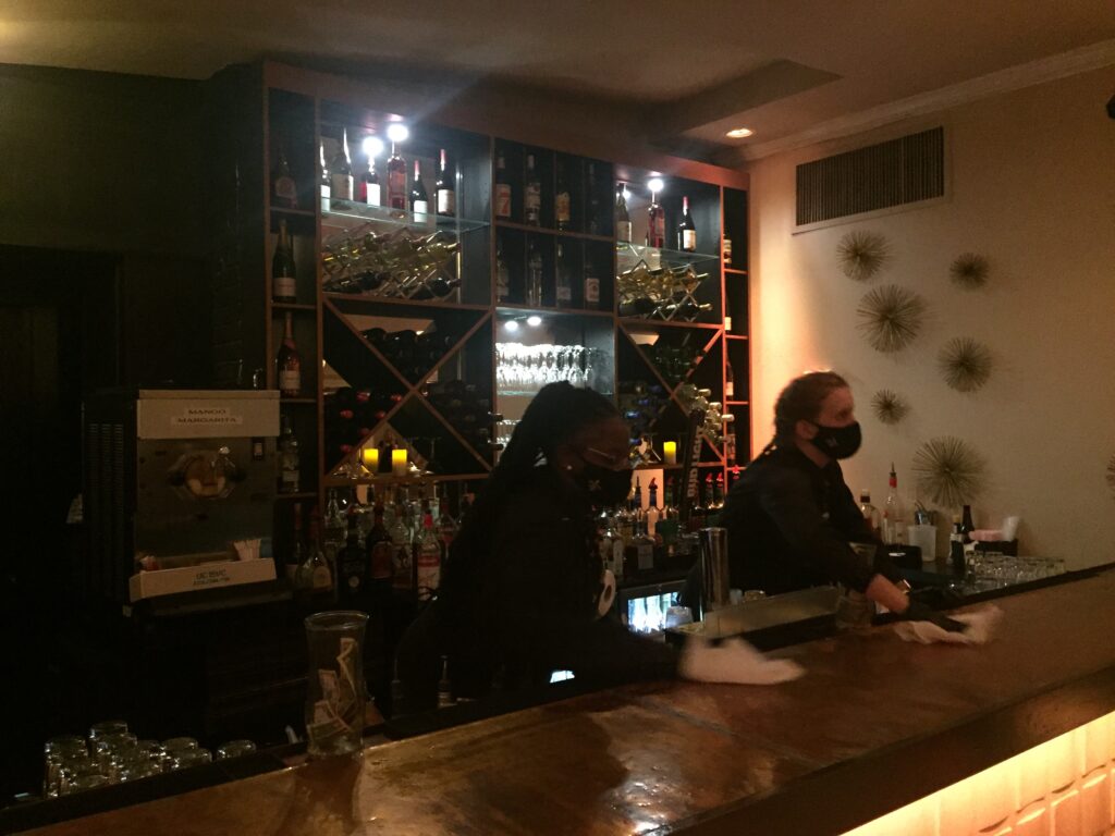 Two bartenders serving drinks