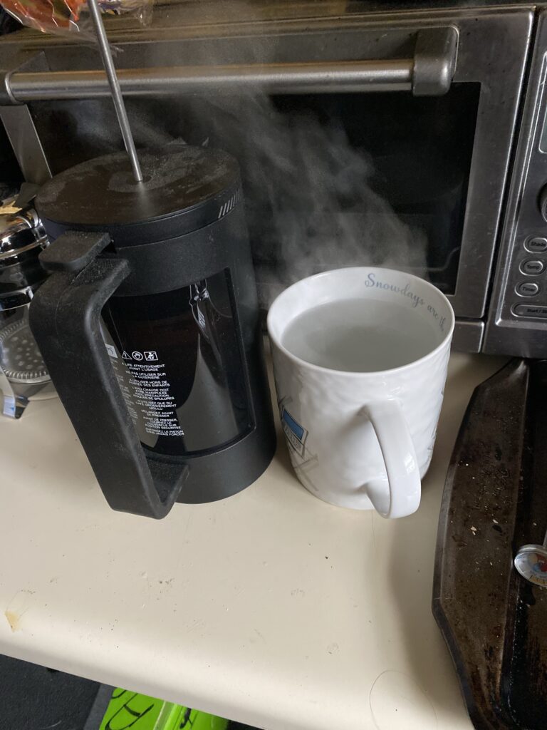 French press coffee pot with cup and hot water steaming