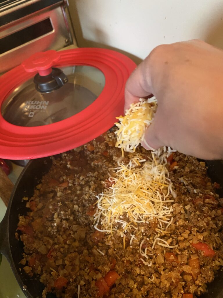 Hand sprinkling cheese into pot