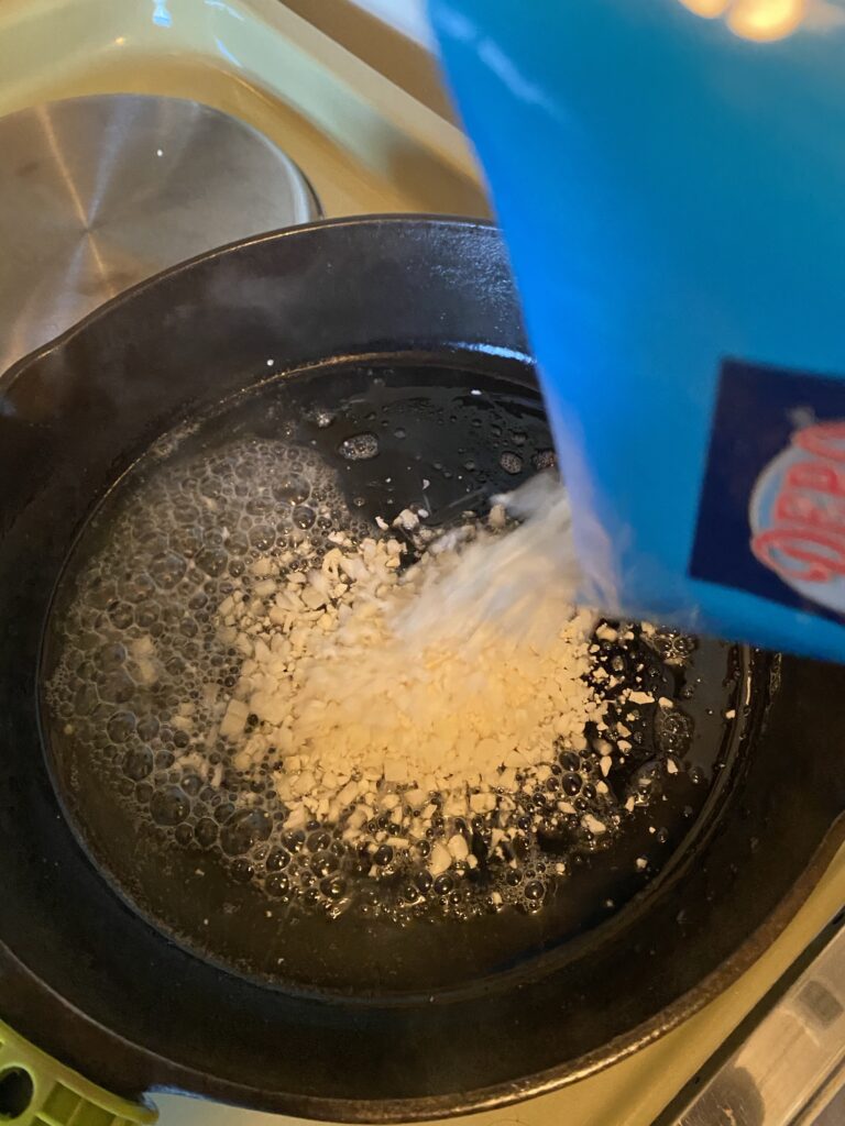 Pouring cauli rice into skillet