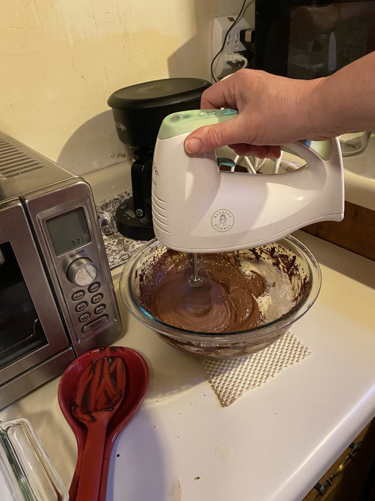 Blending vanilla into the mixture with a hand mixer