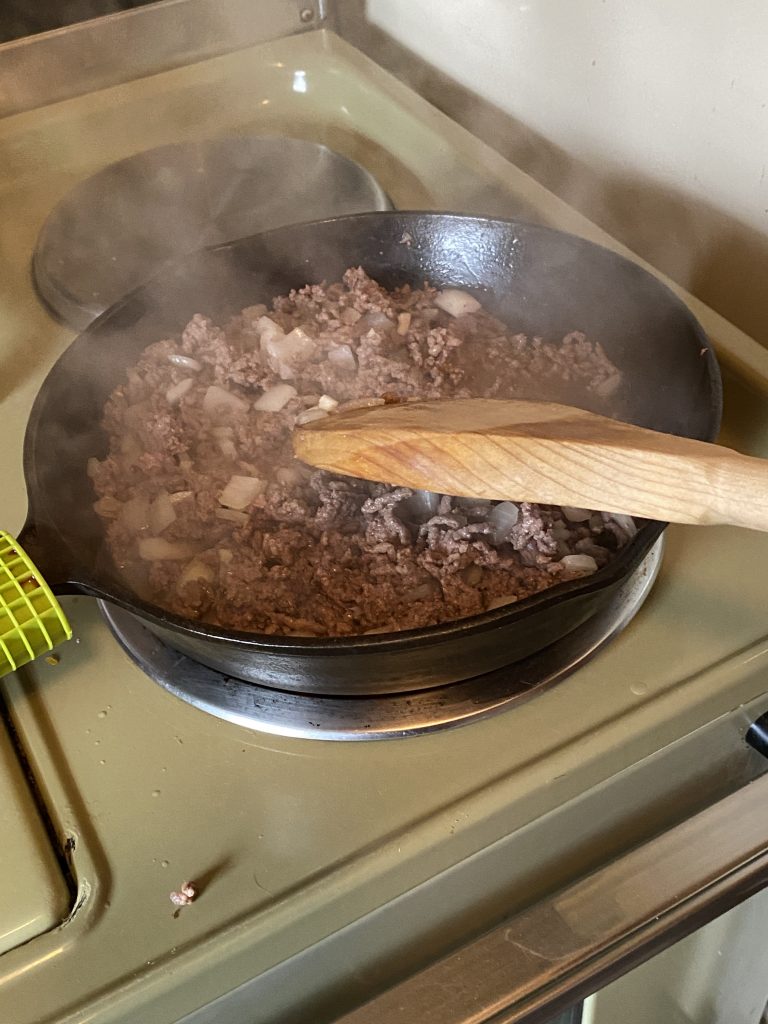Cooked and browned beef in a cast iron skillet