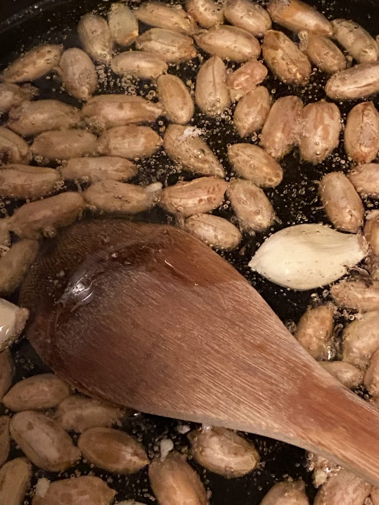 Closeup of frying peanuts and garlic