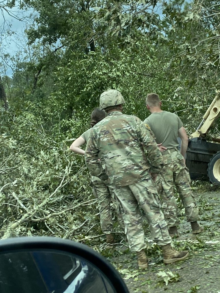 Deployed National Guard members on freeway clearing debris. 