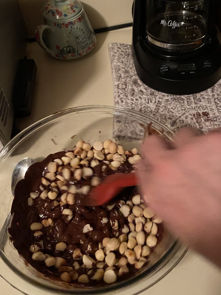 Mixing macadamia nuts into melted chocolate