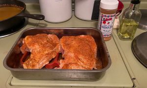 Two chicken thighs coated with chicken rub
