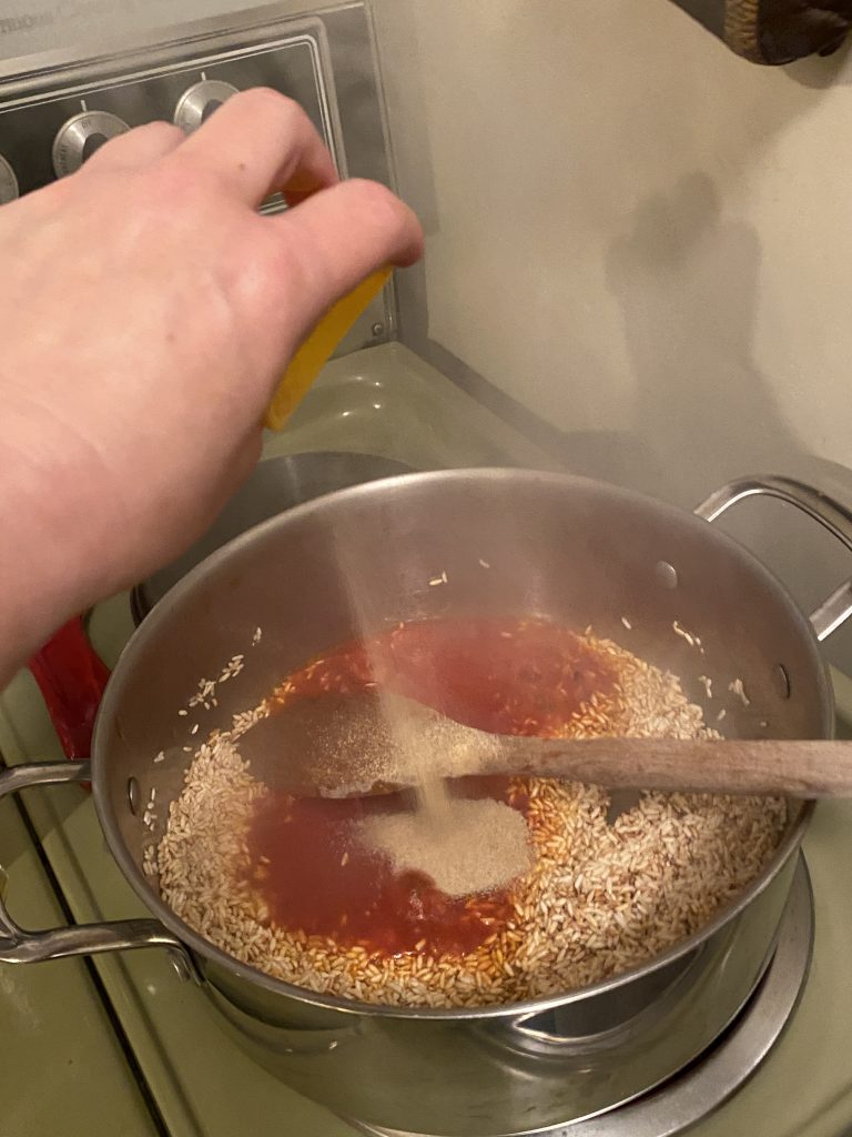Adding Fiesta seasoning to pot