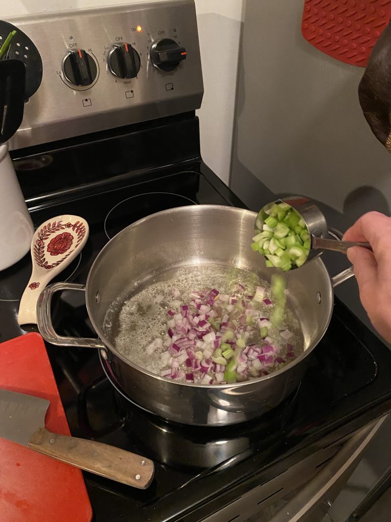 Adding celery and onion to soup pot