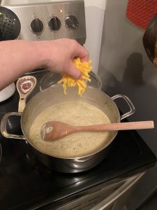 Adding cheese to soup pot