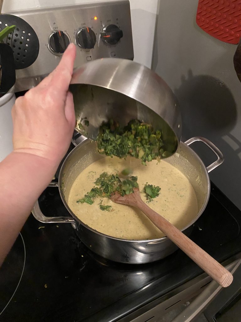 Adding reserved broccoli back into the soup pot