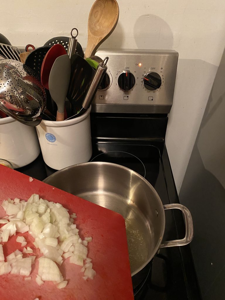 Adding onion and garlic to soup pot