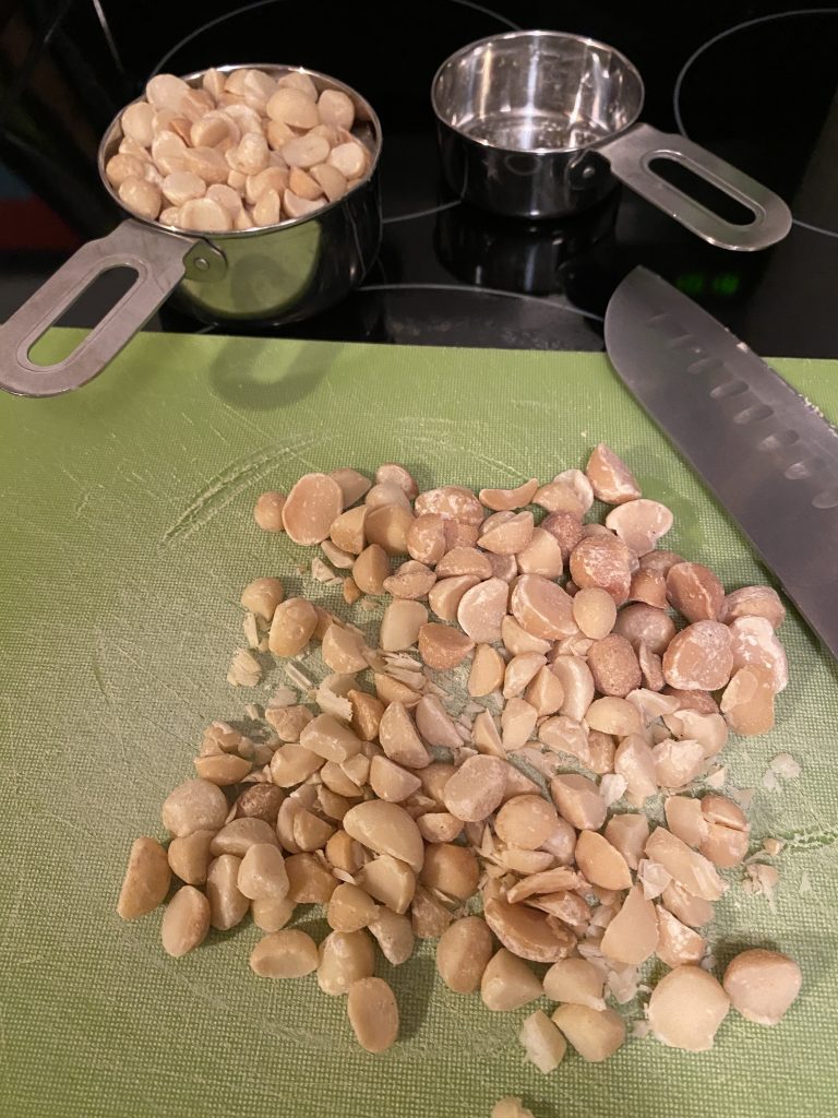 Chopped Macadamia nuts on cutting board 