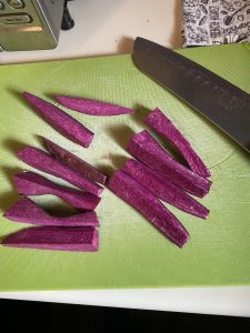 Cut purple sweet potatoes on cutting board with knife