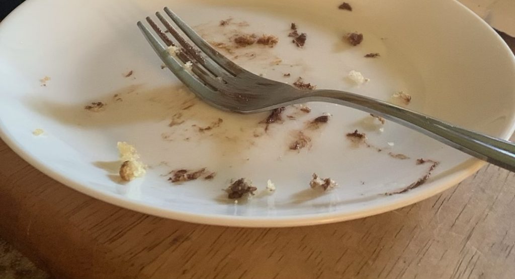 White plate with crumbs and frosting