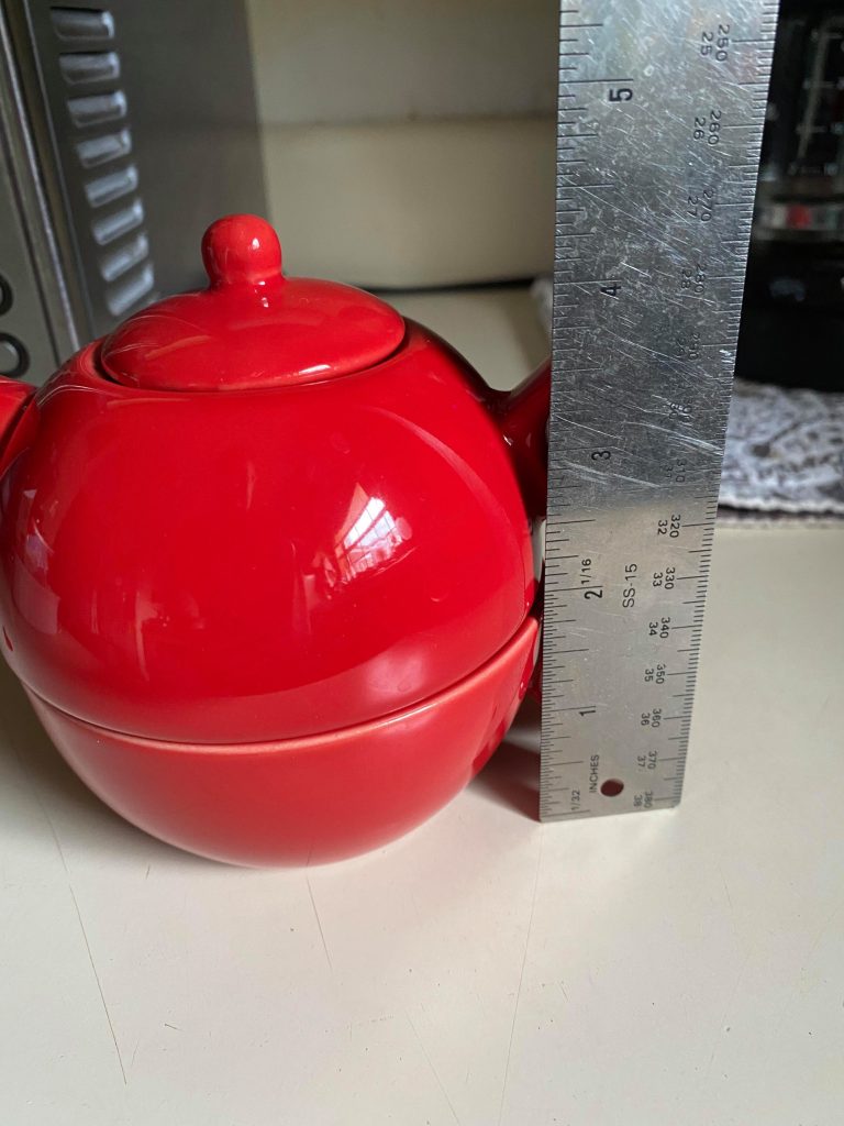 Tea for one pot next to measuring ruler
